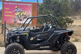 Polaris 2-Seater UTV Rental in front of sign at All Season Adventures, Inc. in Poncha Springs, Colorado.