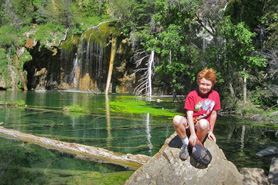 Child on rock in front of Hanging Lake near Aunt Sara's River Dance RV Resort and Campground in Gypsum, Colorado near Vail.