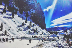 Playing pond hockey with blue sky and sun streaks in Creede, Colorado