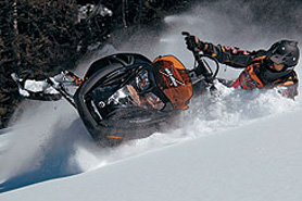 Snowmobiler bursting through snow drift in Grand Lake, Colorado