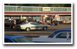 Classic cars parked in front of Snow Dogs Hot Dogs, Chicago Style Hot dogs in Colorado