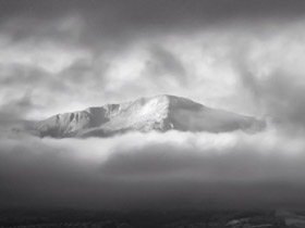 The top of Pikes Peak Mountain, aka  Tava - Sun Mountain, surrounded by clouds in Colorado's Rocky Mountains.