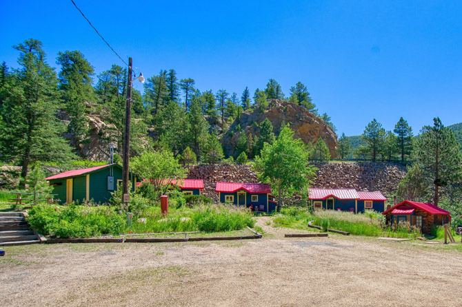Log Cabins under a clear blue sky in the spring at Raymond Store Cabins between Lyons and Allenspark, Colorado.