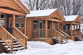 Outdoor view of family log cabins covered in fresh snow in the winter at Healing Waters Resort and Spa near Durango in Pagosa Springs, Colorado.